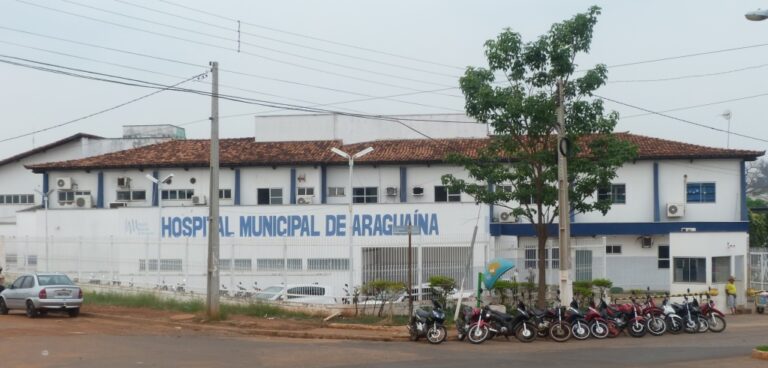 Imagem da fachada do Hospital Municipal de Araguaína. Na frente do prédio há uma carro e dezenas de motos estacionadas.