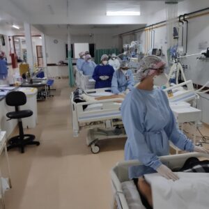 Imagem da UTI do Hospital Regional de Gurupi. Há vários leitos ocupados por pacientes em uma sala grande. Ao lado de cada leito há profissionais da Enfermagem.