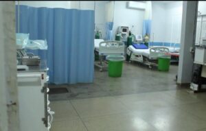 Imagem mostra uma sala com leitos hospitalares, um ao lado do outro. Uma cortina azul também aparece na imagem.