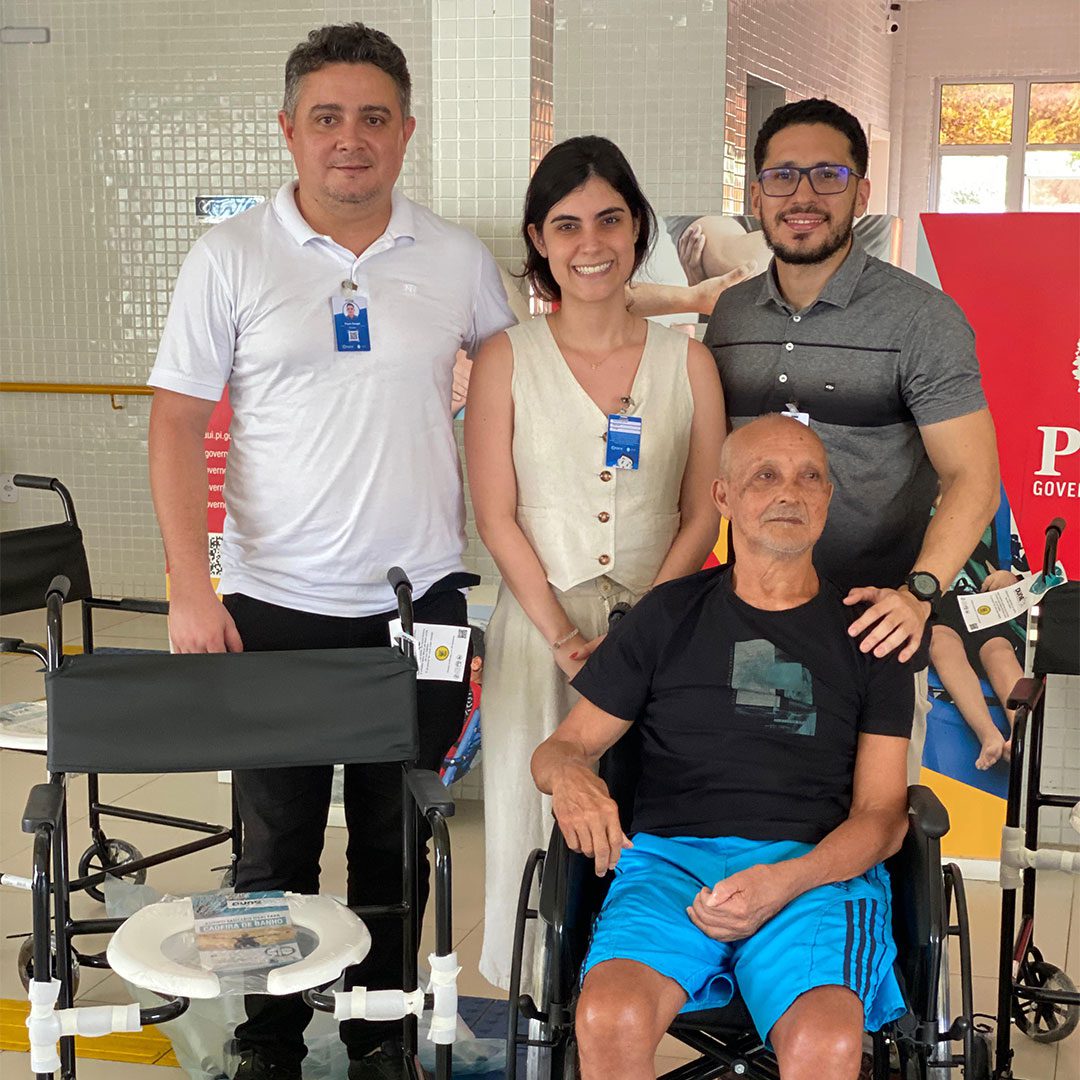 Benedito (dir.) e o pai, Francisco, comemoram a chegada das cadeiras de rodas e outros equipamentos de mobilidade. (Foto: Camila Neto)